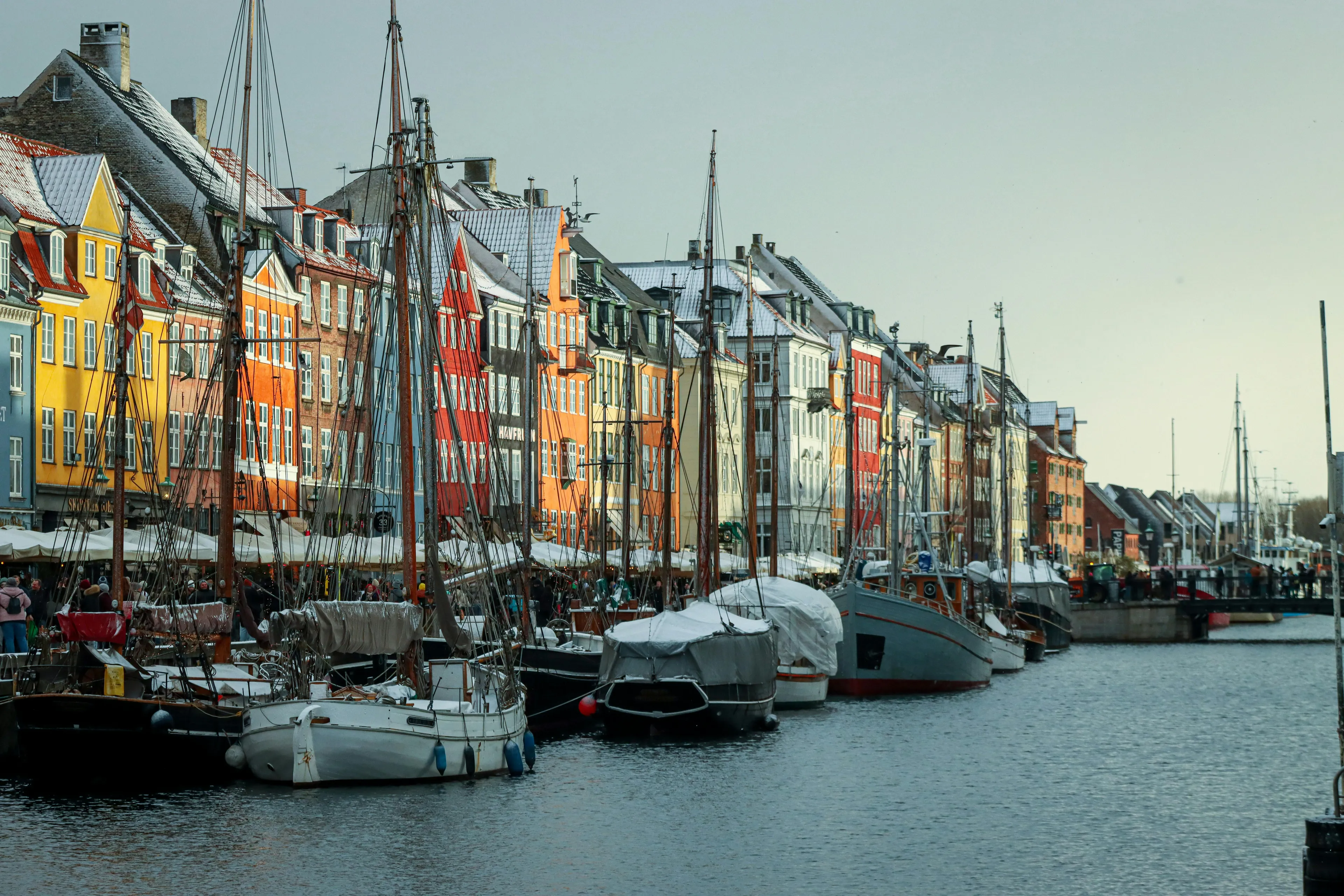Colorful buildings and boats along a snowy canal in a European city, guessing countries travel destination quiz.