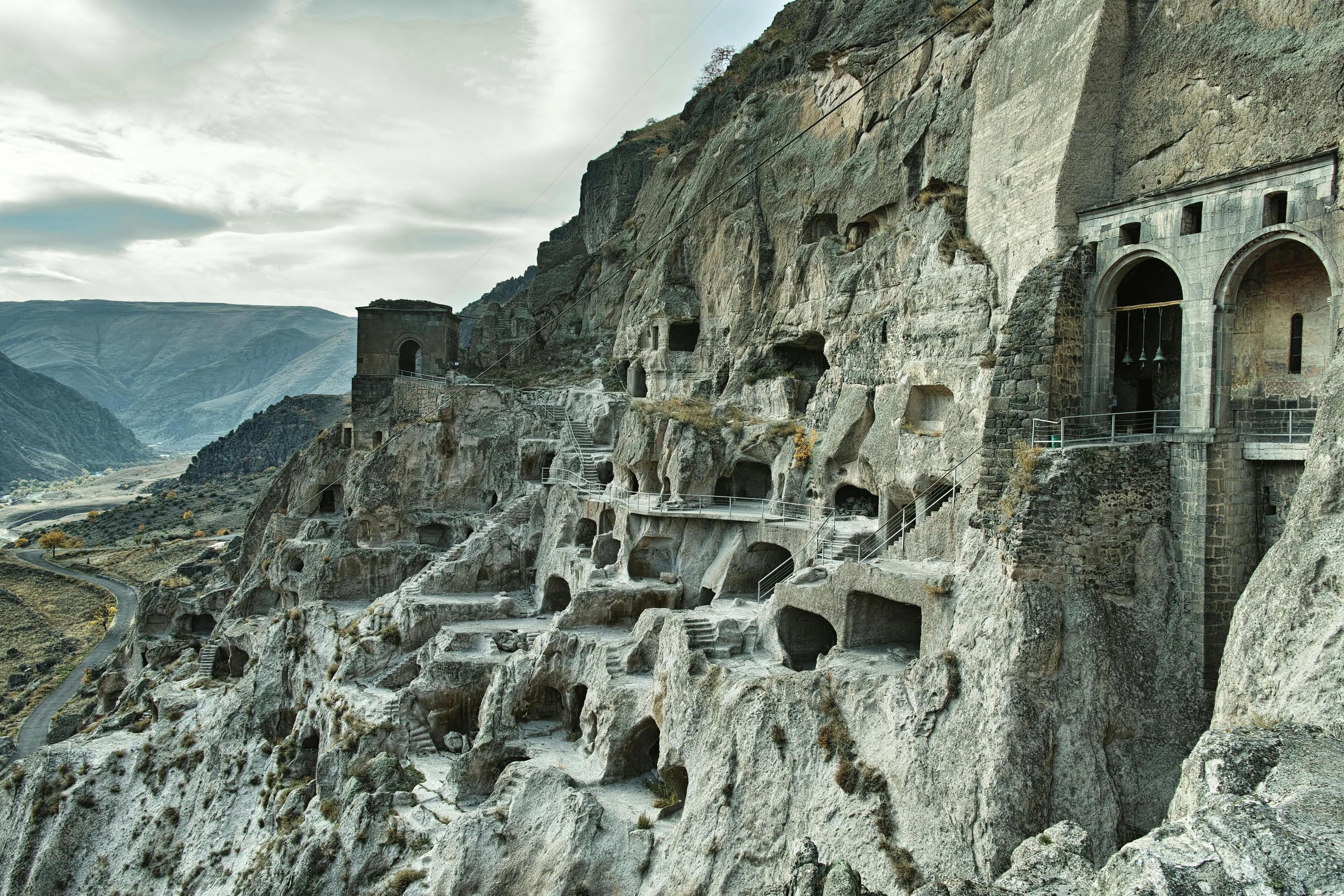Rock-carved city of Vardzia in Georgia with cliff dwellings and mountainous European landscape in the background