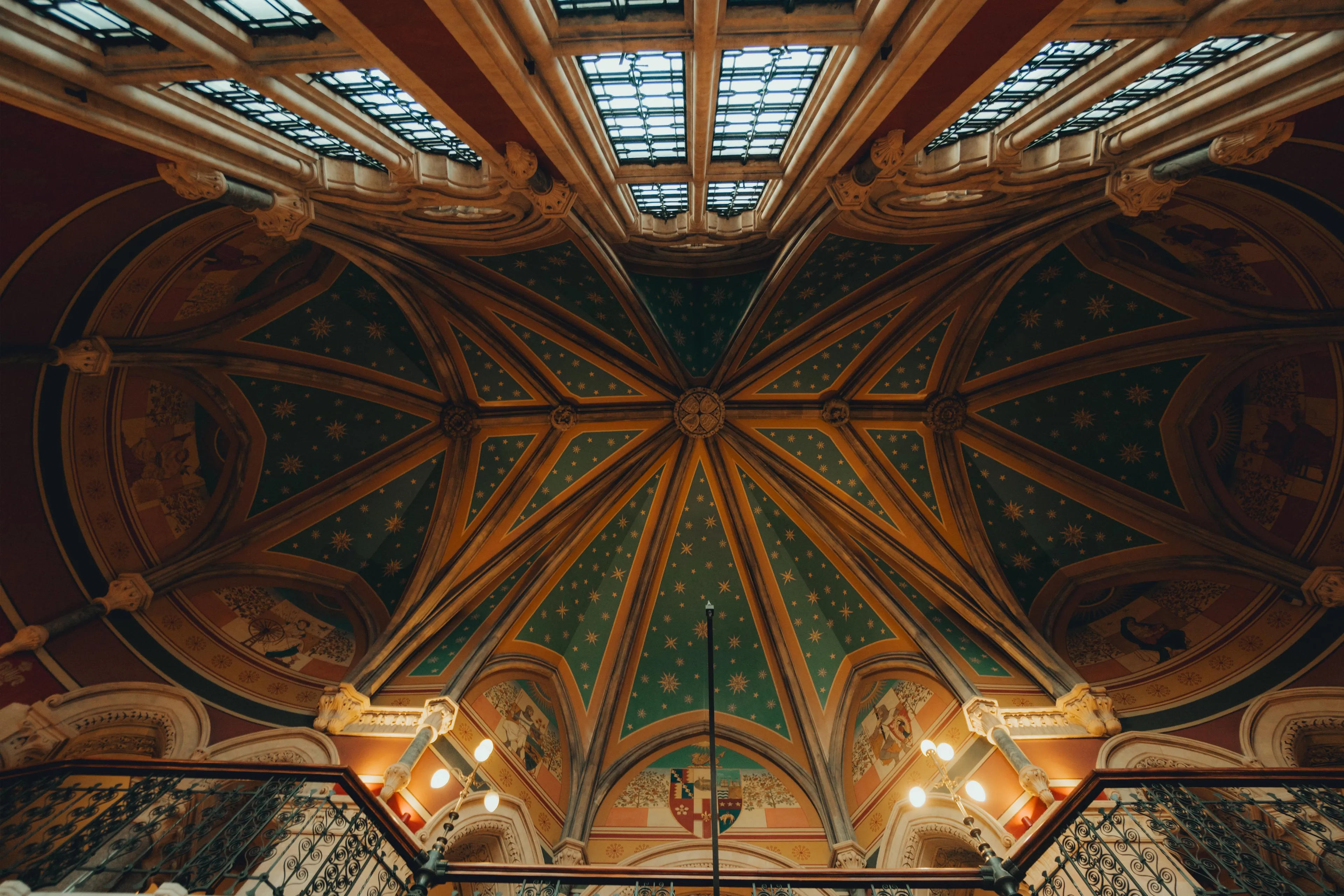 Ornate Renaissance-style ceiling with intricate arches and detailed artwork, highlighting famous artists of the Renaissance period.
