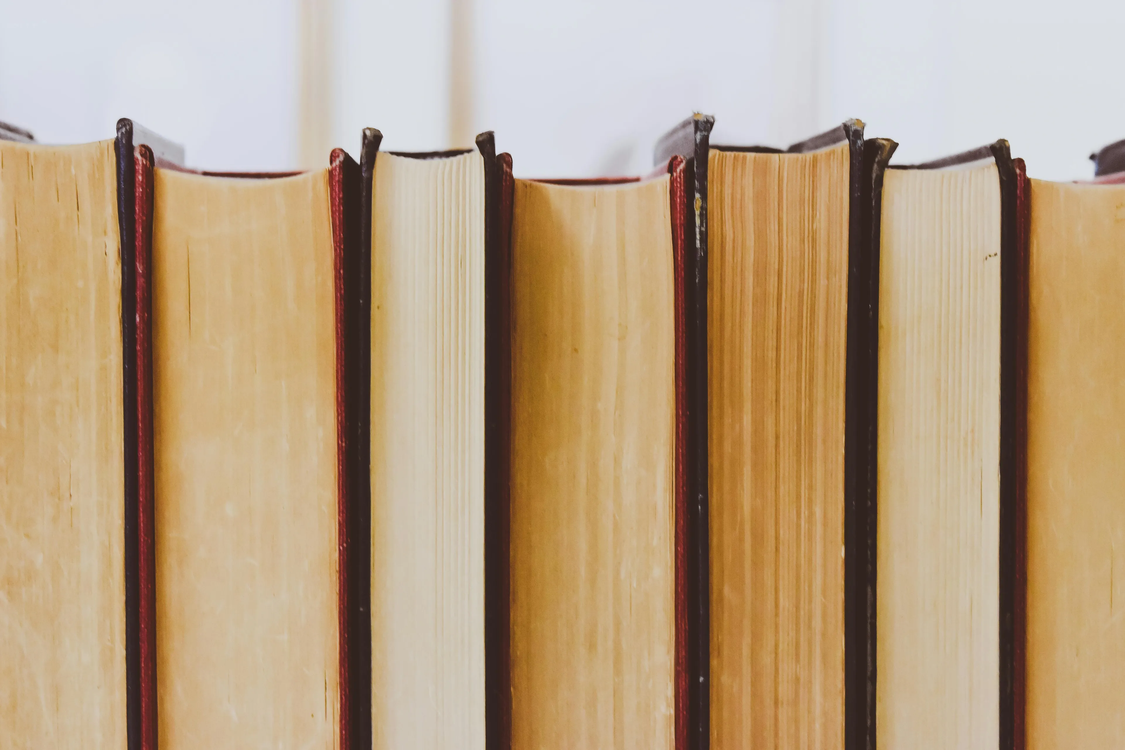 Close-up of old books standing upright, representing history and learning about the Industrial Revolution in the 18th-19th centuries.