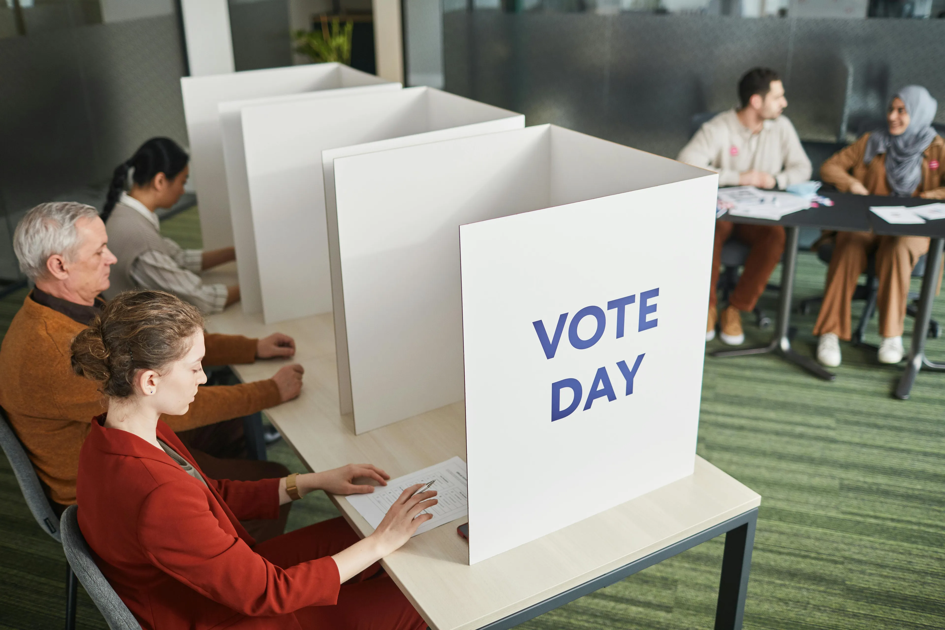 Voters casting ballots at voting booths on vote day, illustrating civics and democracy participation concepts.