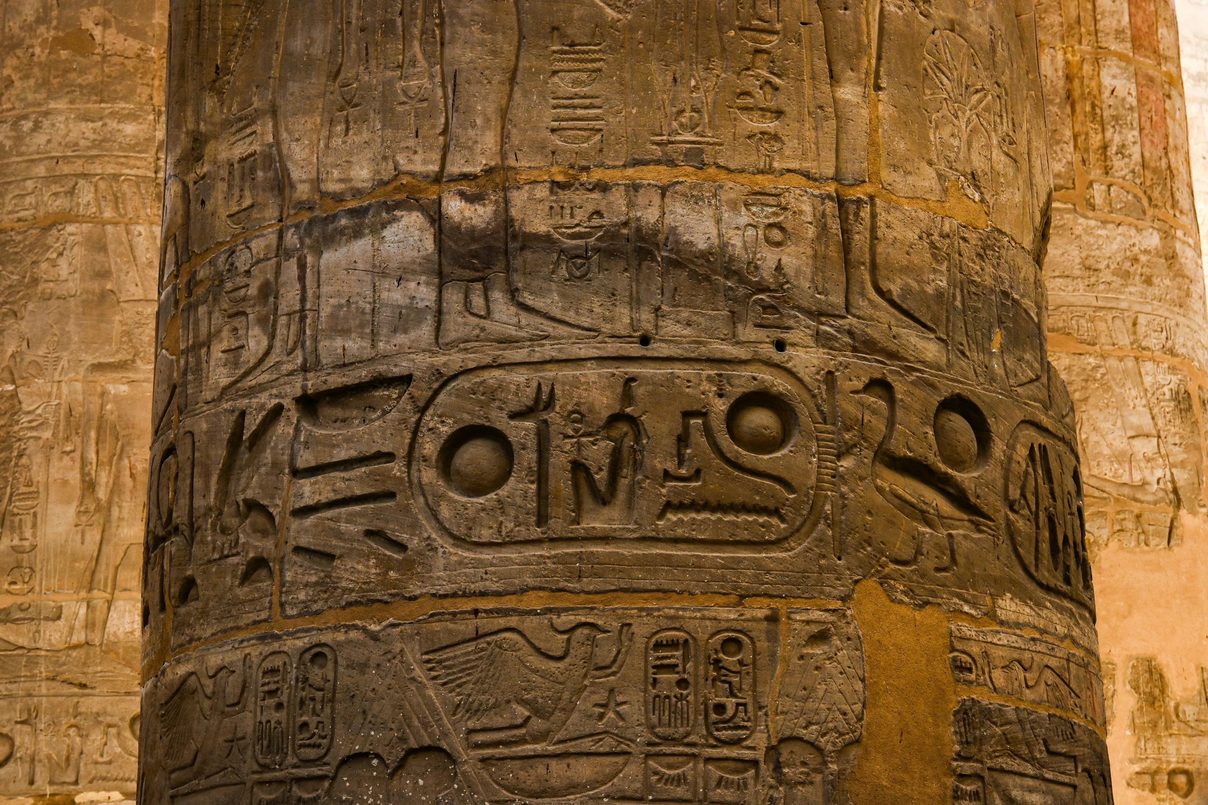 Ancient Egyptian hieroglyphs carved into a stone pillar, illustrating the first system of writing in history.