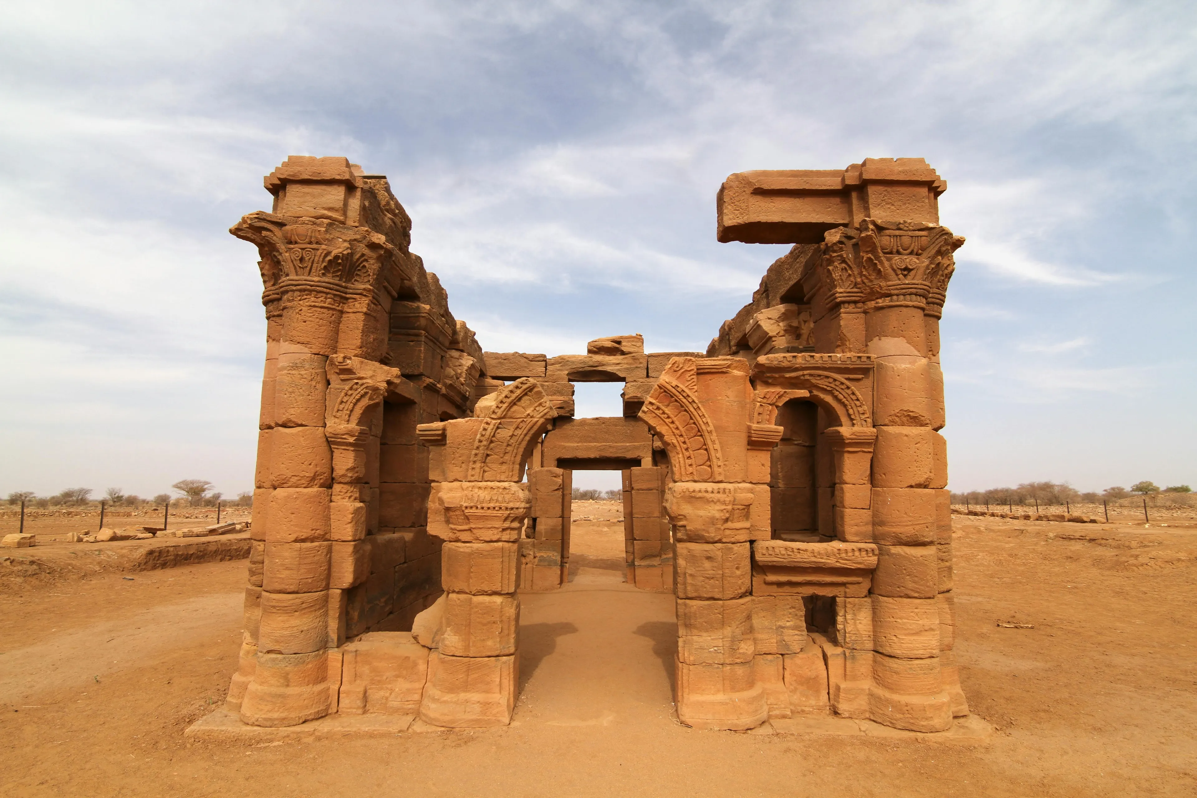 Ancient stone ruins with arches and columns standing in the desert landscape of South Sudan.