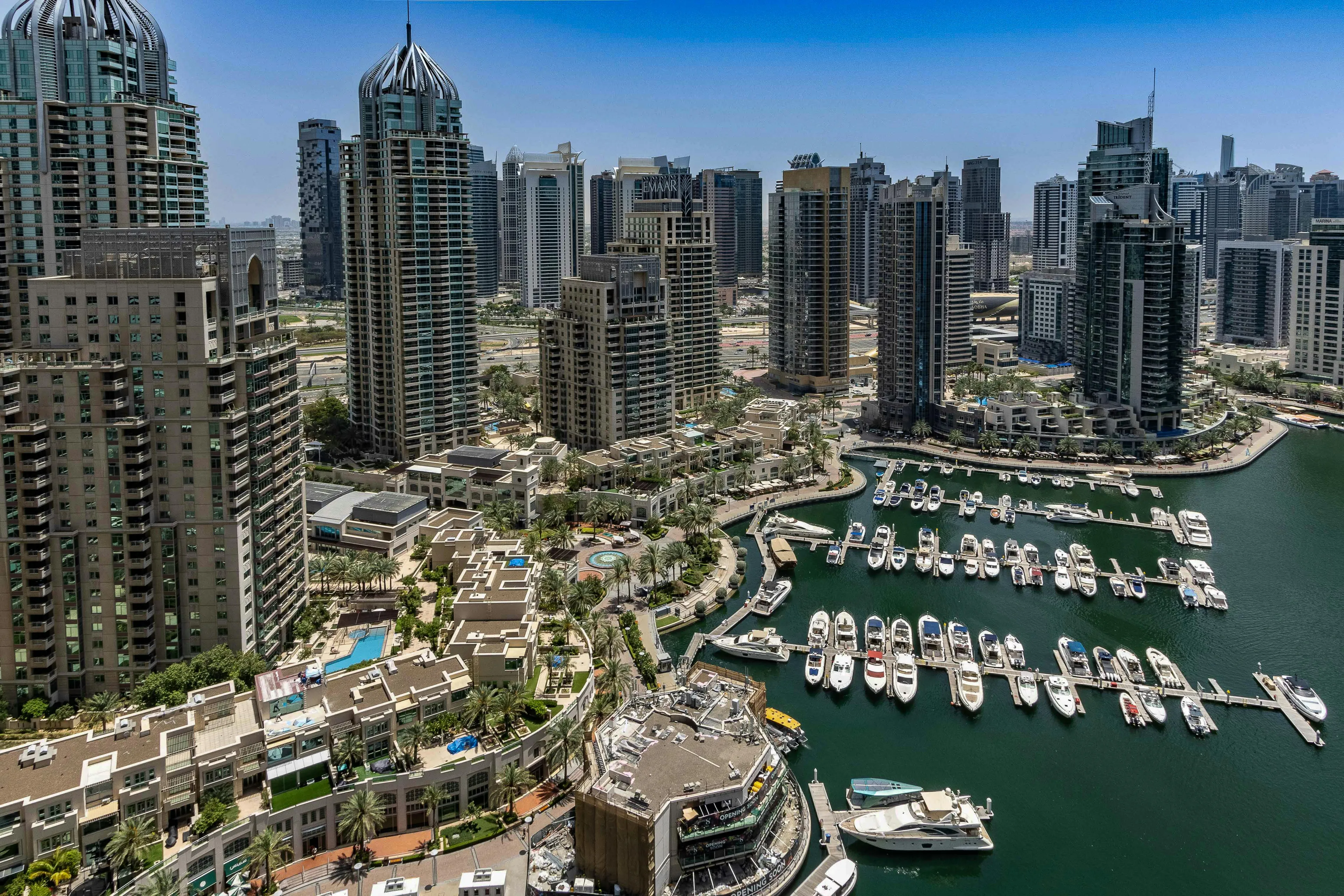 Aerial view of Dubai Marina with skyscrapers and yachts in the harbor, a landmark in the United Arab Emirates cityscape.