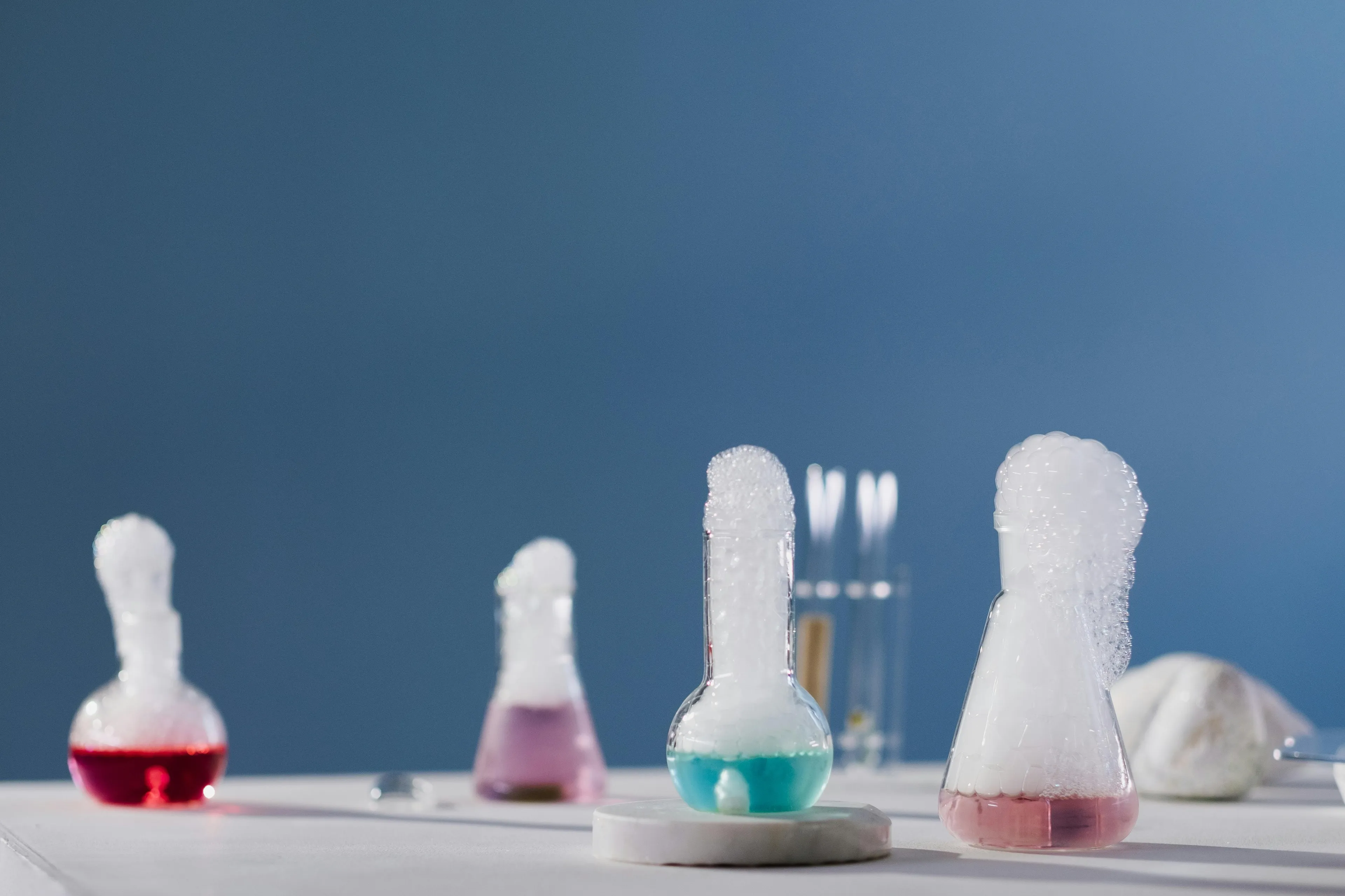 Laboratory flasks with colorful bubbling chemicals demonstrating changes in reaction rate in chemistry experiments.