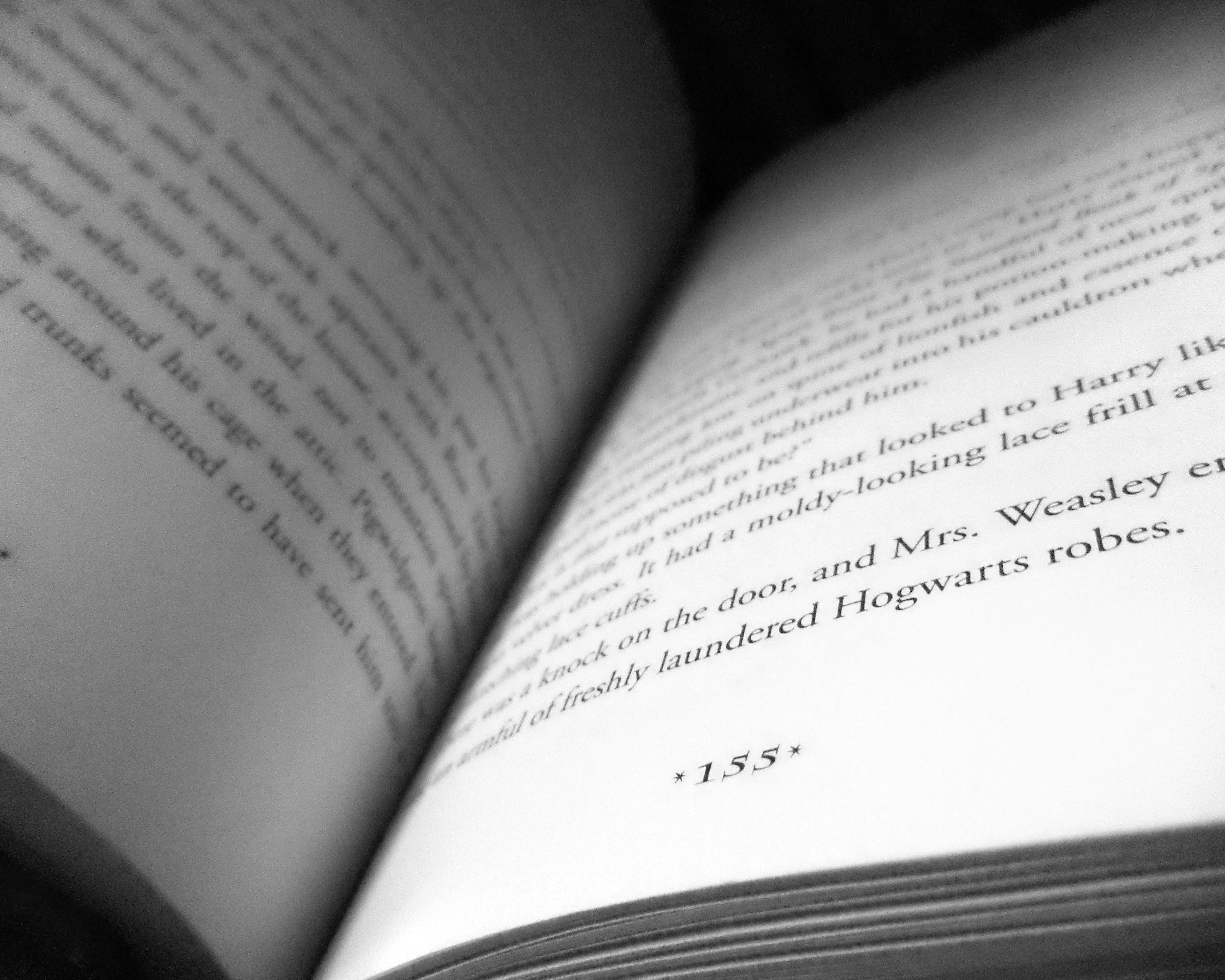 Open book close-up showing printed text about Hogwarts robes, illustrating literature story central message concept.