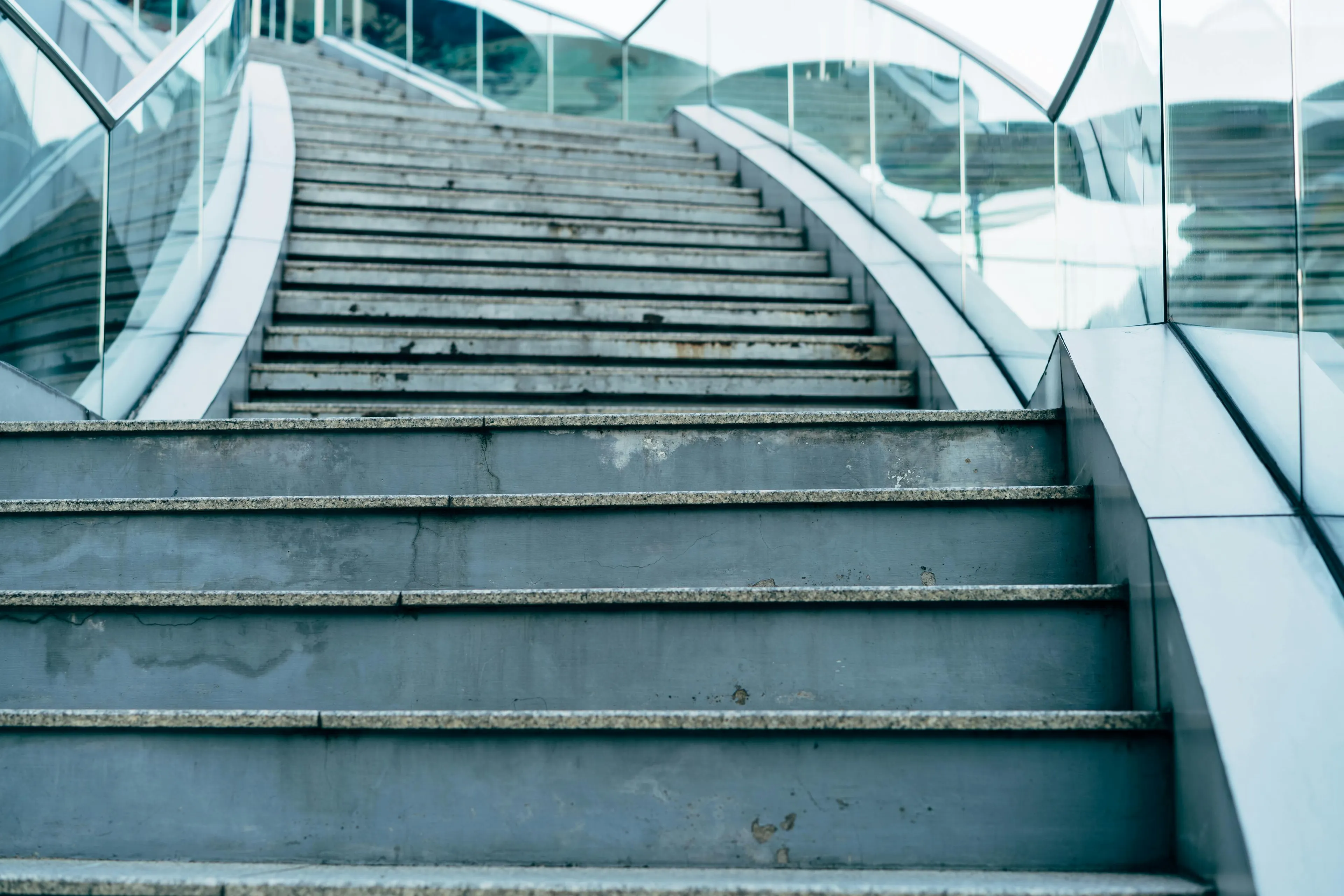 Concrete stairs with glass railings and steps leading upward in a modern architectural setting school biology question concept