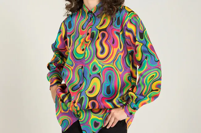 Person wearing a vibrant psychedelic shirt with swirling colorful patterns, showcasing a bold fashion accessory style.