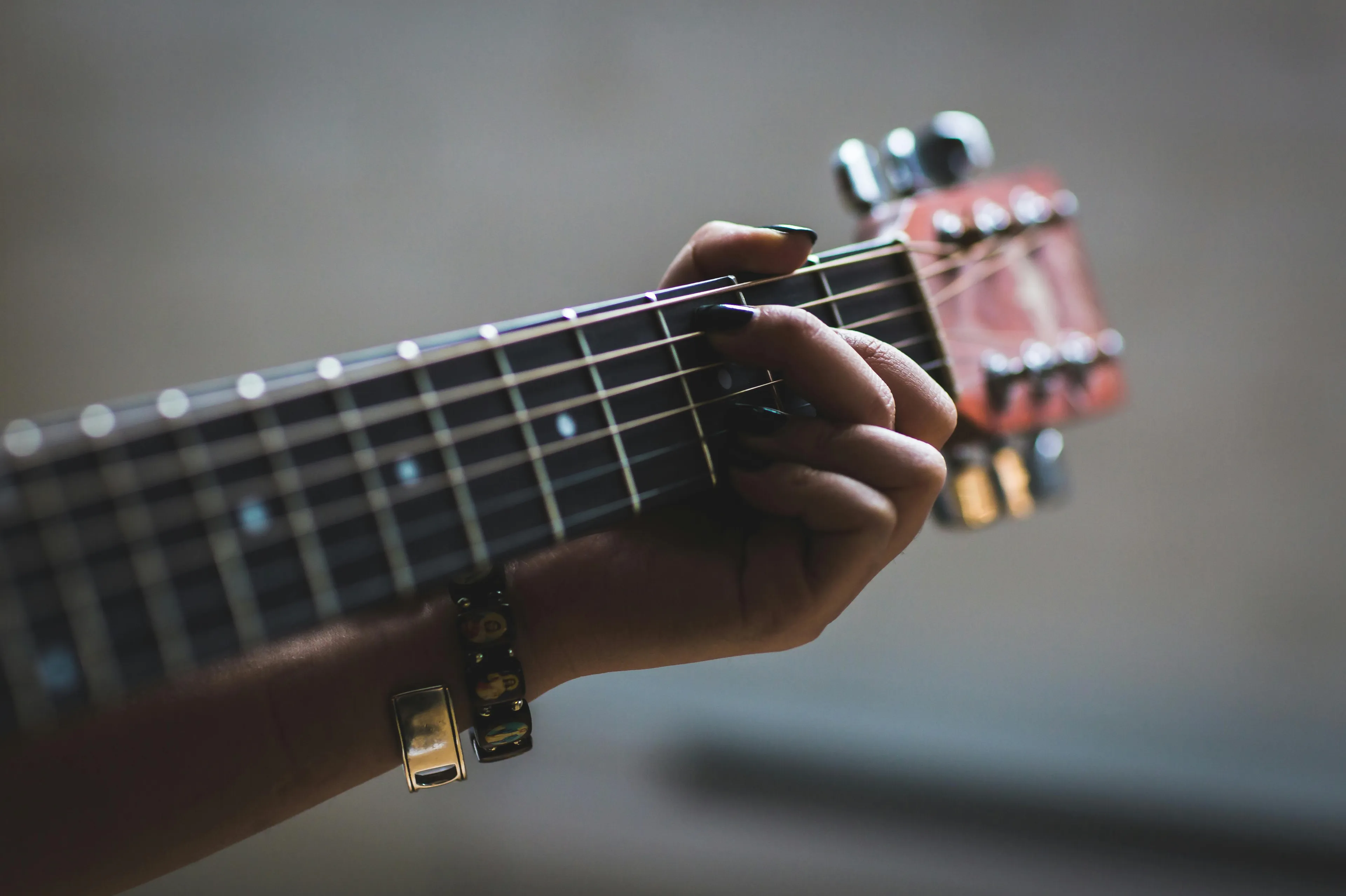 Close-up of a hand playing guitar strings, evoking favorite decade for music vibes and relaxed sitcom moments.