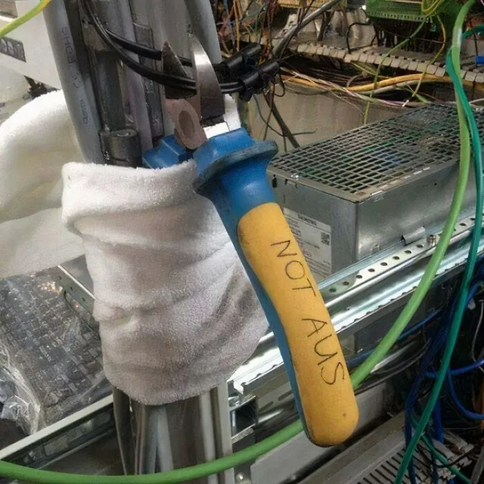 Improvised electrical setup with a towel insulation and a tool handle labeled not AUS demonstrating if it's stupid but it works concept.