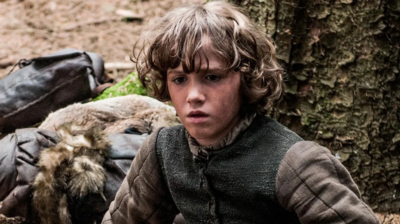 Young supporting character from Game of Thrones sitting in a forest, wearing medieval-style clothing and looking pensive