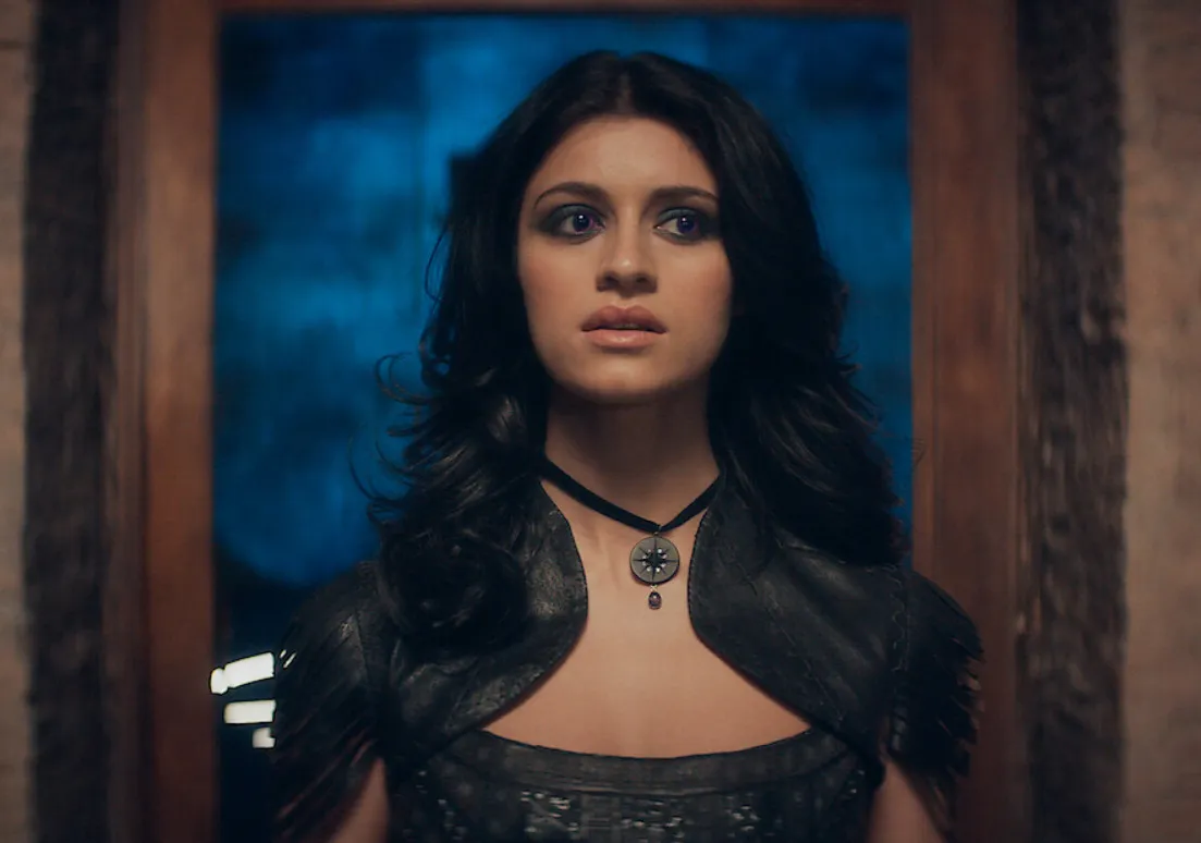 Young woman in dark medieval attire with a pendant, portraying a mentor character from The Witcher related to Yennefer.