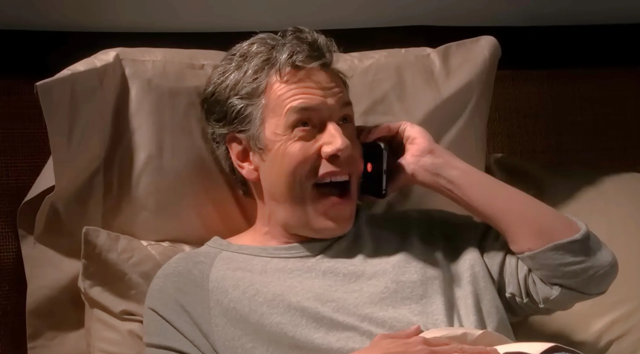 Barry Kripke lying in bed talking on phone in a scene related to The Comic Center of Pasadena in The Big Bang Theory.