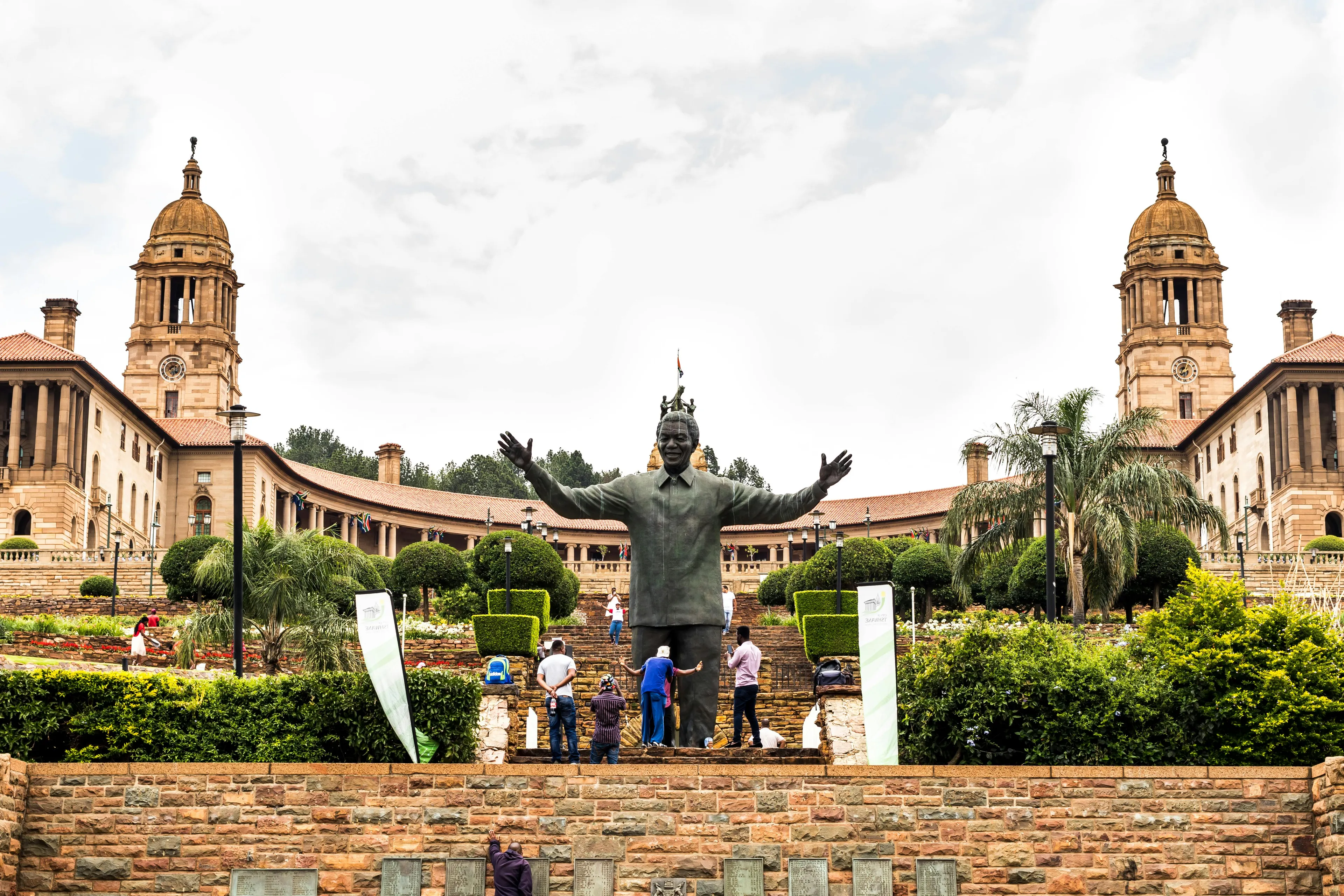 Statue of Nelson Mandela in front of the Union Buildings in Pretoria, capital city of South Africa with visitors around.