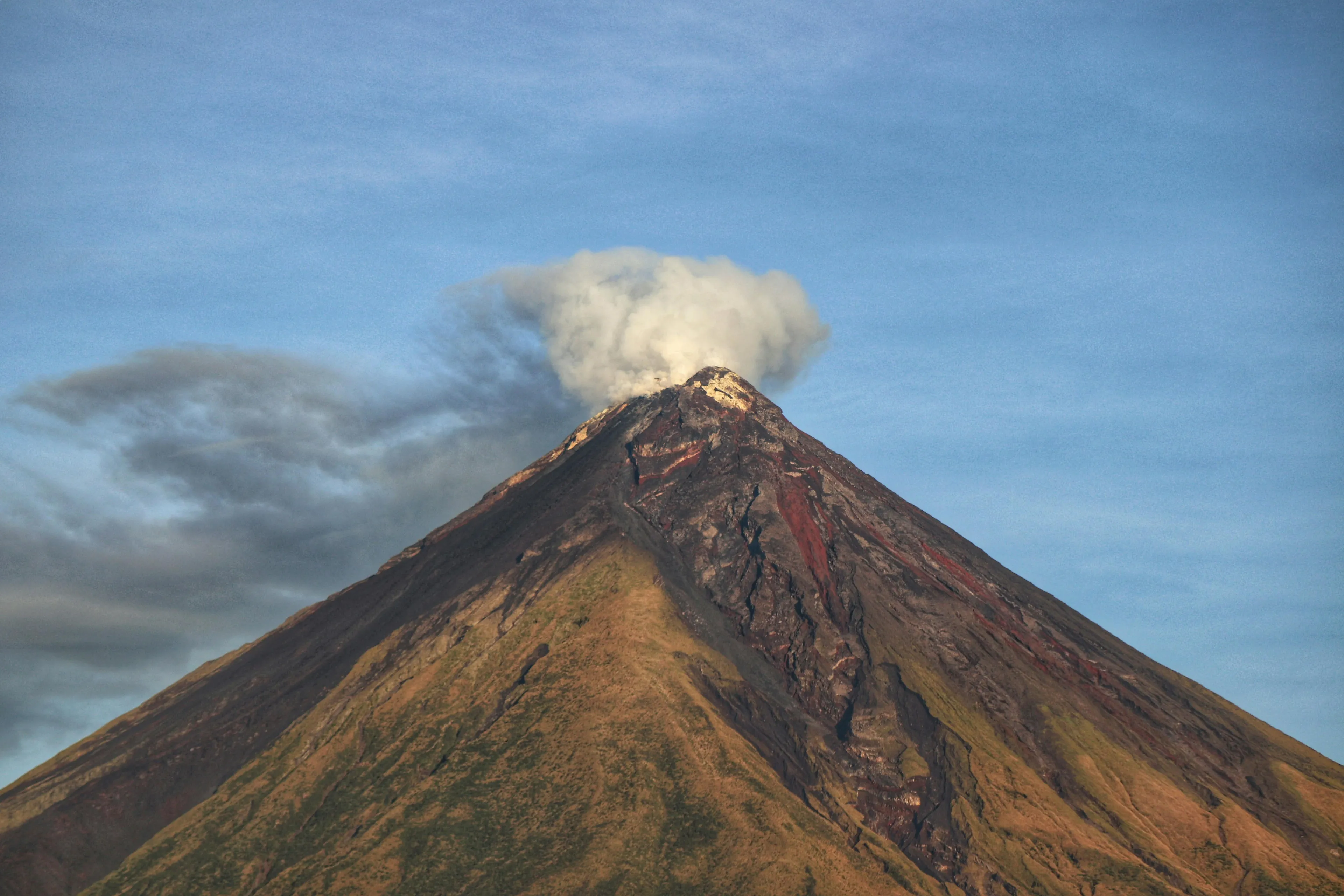 Active volcano emitting smoke under a clear blue sky, illustrating geography true-or-false questions about volcanoes in Europe.