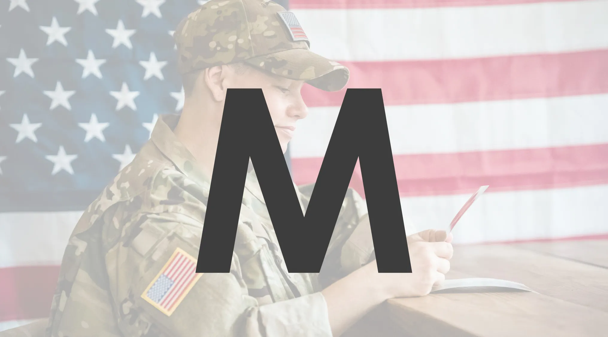 Soldier in uniform writing with an American flag in the background, representing NATO Morse Code and military alphabet M word.