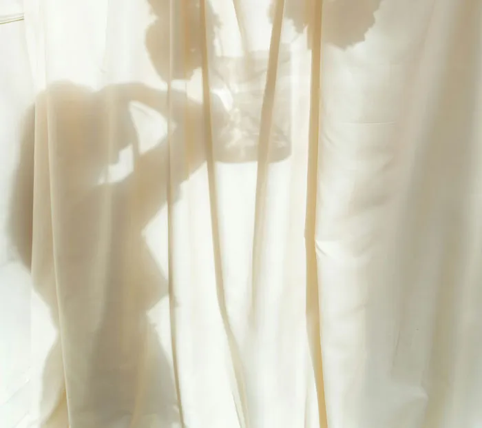 Silhouetted person behind curtain adjusting hat, backlit, friends family weird anecdote illustration