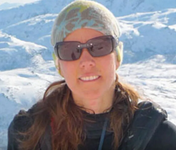 Woman wearing sunglasses and a beanie in snowy mountains, illustrating unusual medical facts that sound made up but are true.