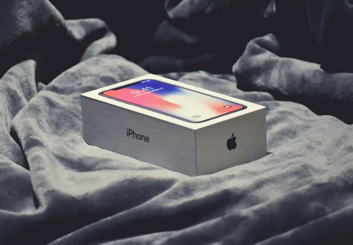 iPhone box on soft fabric background symbolizing the role of phone in revealing cheating secrets