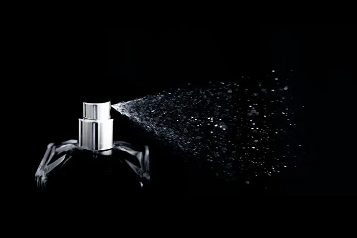 Perfume bottle spraying mist in a dark setting, symbolizing the importance of the phone in cheating revelations.