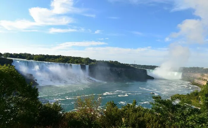 View of a large waterfall and river under a blue sky, illustrating disappointing tourist attractions locals still don’t get.