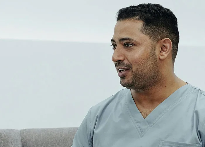 Medical professional in scrubs speaking to a patient, illustrating worst things medical professionals have said.