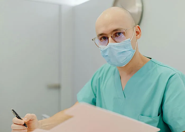 Medical professional in scrubs and mask reviewing patient files, illustrating worst things medical professionals say.