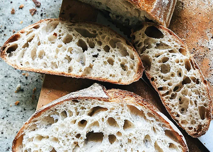 Close-up of sliced sourdough bread with airy texture symbolizing unexpected medical issues and health challenges.