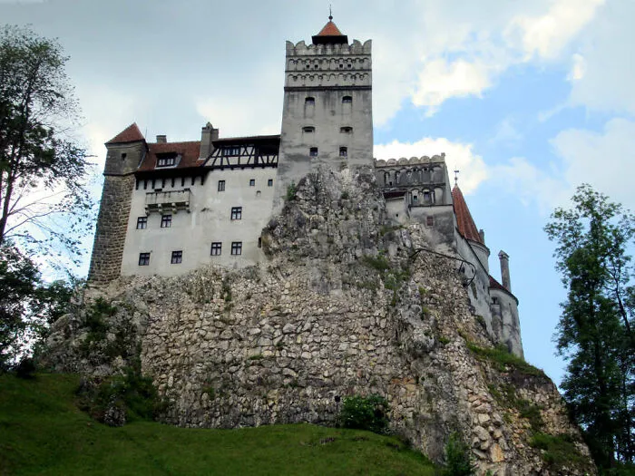 Castle perched on rocky hill surrounded by trees, representing disappointing tourist attractions locals still don’t get.