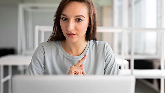 Young woman in a gray shirt during a virtual interview, demonstrating how job candidates instantly lost their chance at a job.