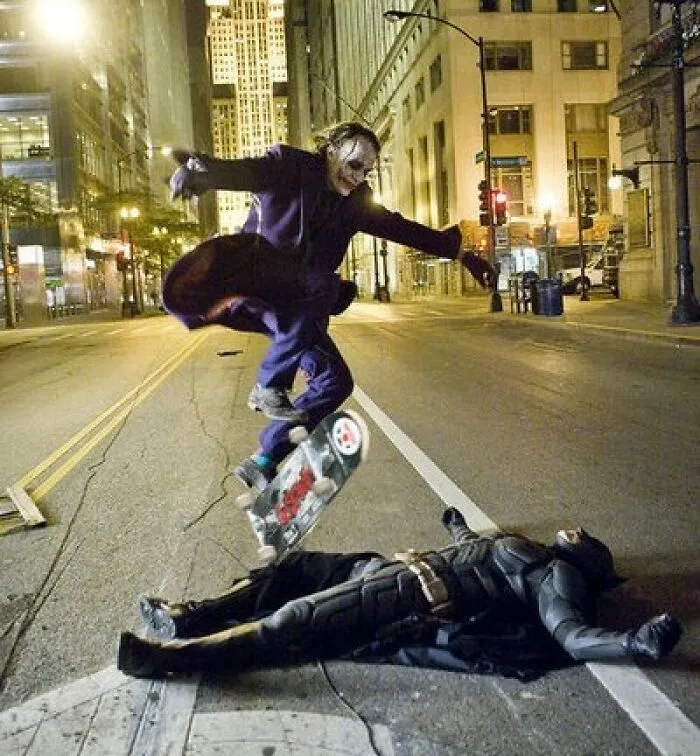 Joker character skateboarding over Batman lying on city street in a staged scene that fooled the internet.