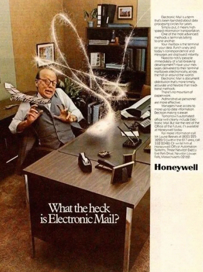 Hombre sorprendido usando correo electrónico en una oficina vintage, mostrando productos antiguos que ahora parecen extraños.