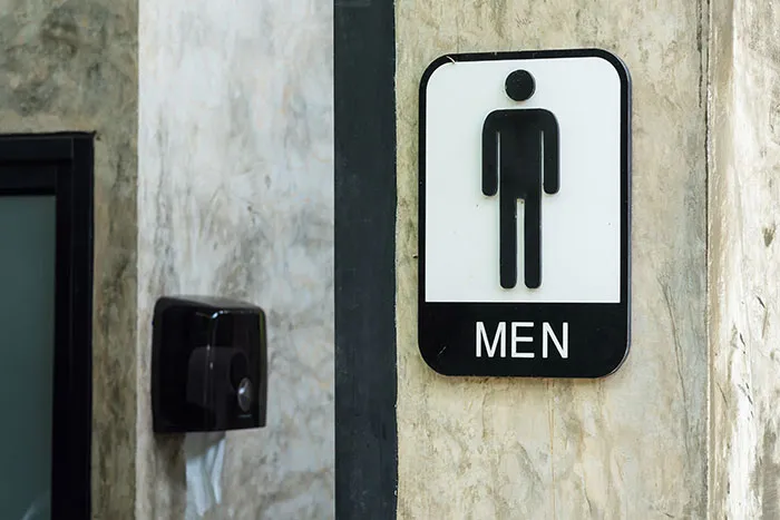 Men restroom sign on a textured wall, symbolizing things about men women often want to understand better.
