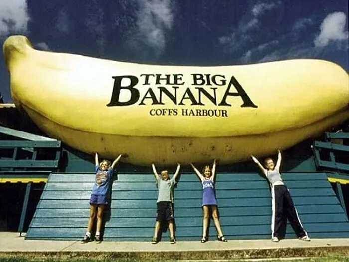 Children posing in front of The Big Banana in Coffs Harbour, a well-known disappointing tourist attraction.