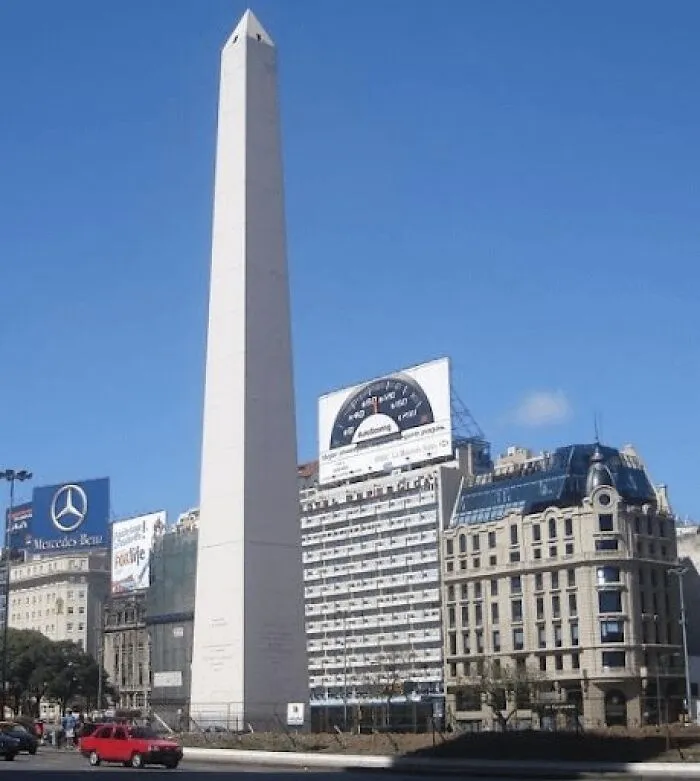 Obelisk landmark in a city square with surrounding buildings and traffic, a popular but disappointing tourist attraction.