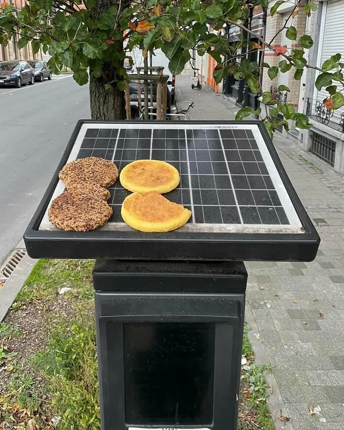 Solar panel on a street device in Brussels used to cook or dry unusual food items, showcasing weirdest street sights.