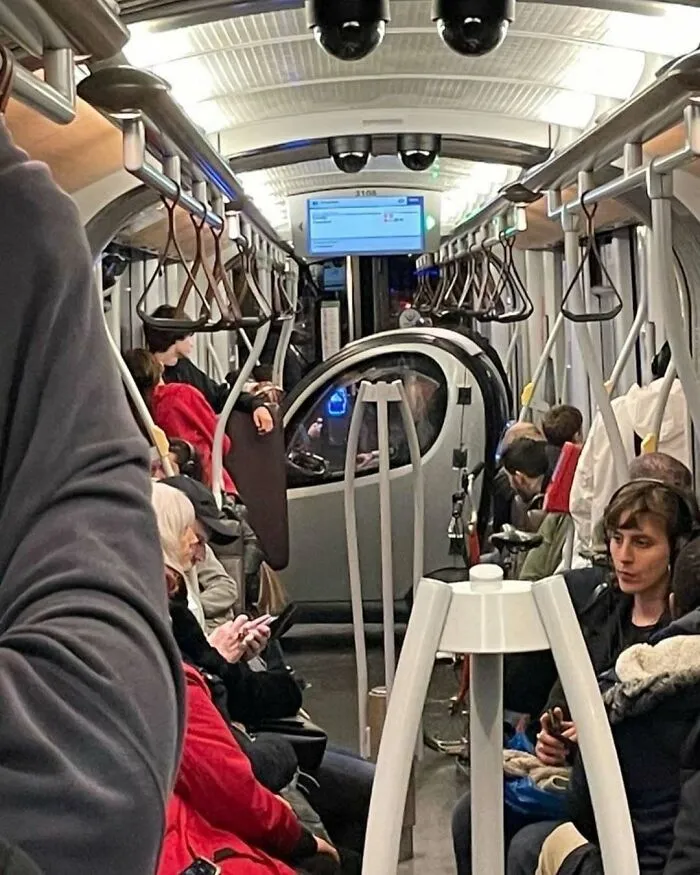 Passengers sitting and standing inside a crowded Brussels tram, showcasing one of the weirdest and most unhinged street scenes.