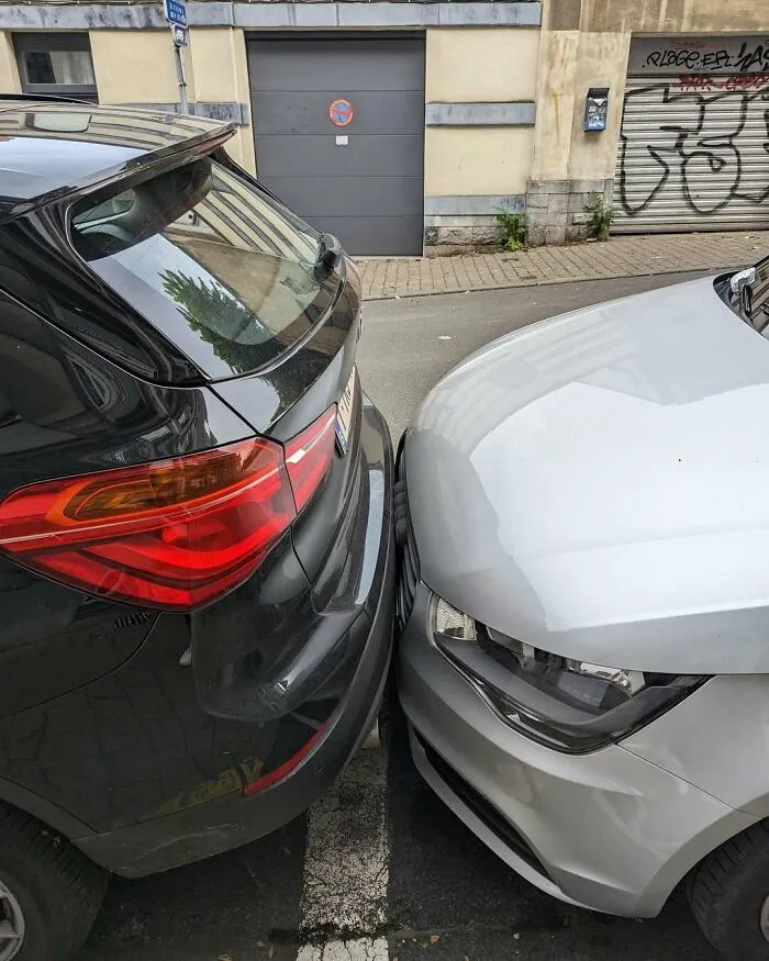Two cars parked unusually close bumper to bumper on a narrow street in Brussels showcasing weird street parking behavior.