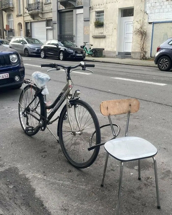 Unusual bike locked to a chair on a street in Brussels, showcasing one of the weirdest and most unhinged things seen.