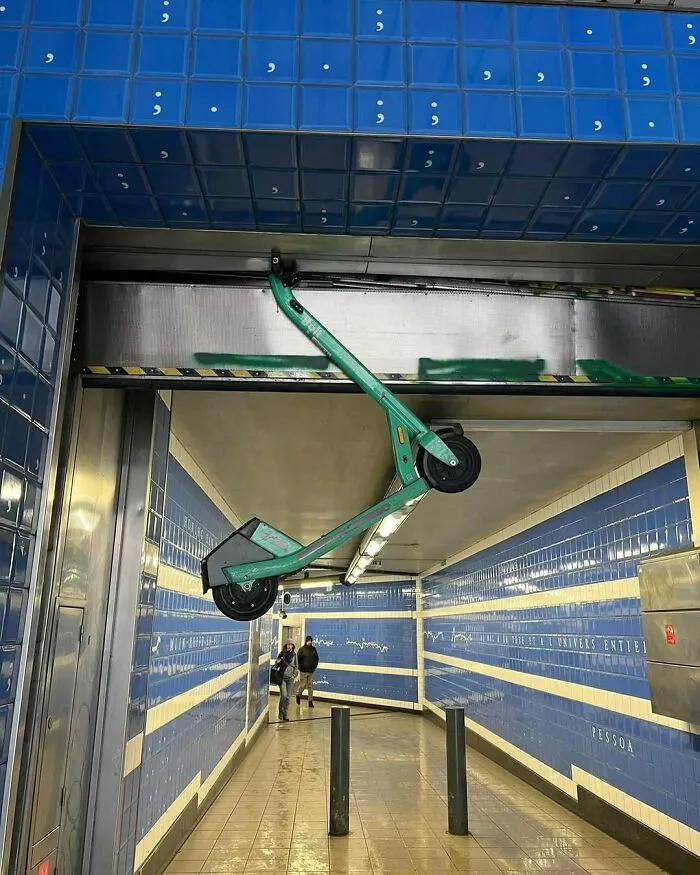 Electric scooter hanging upside down in a tiled Brussels subway, one of the weirdest and unhinged things seen on the streets