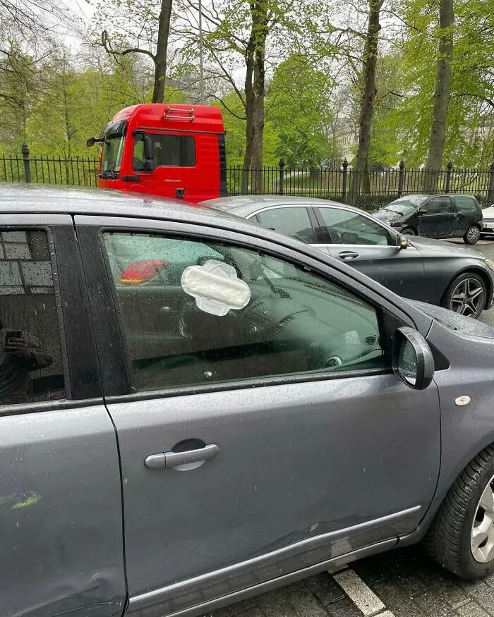 Car window in Brussels with a sanitary pad stuck inside, showing one of the weirdest and most unhinged things on the streets.