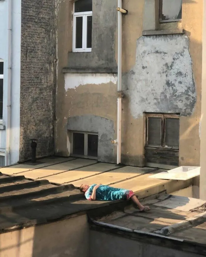 Person lying on a rooftop in bright clothing among the weirdest and most unhinged things seen on the streets of Brussels.