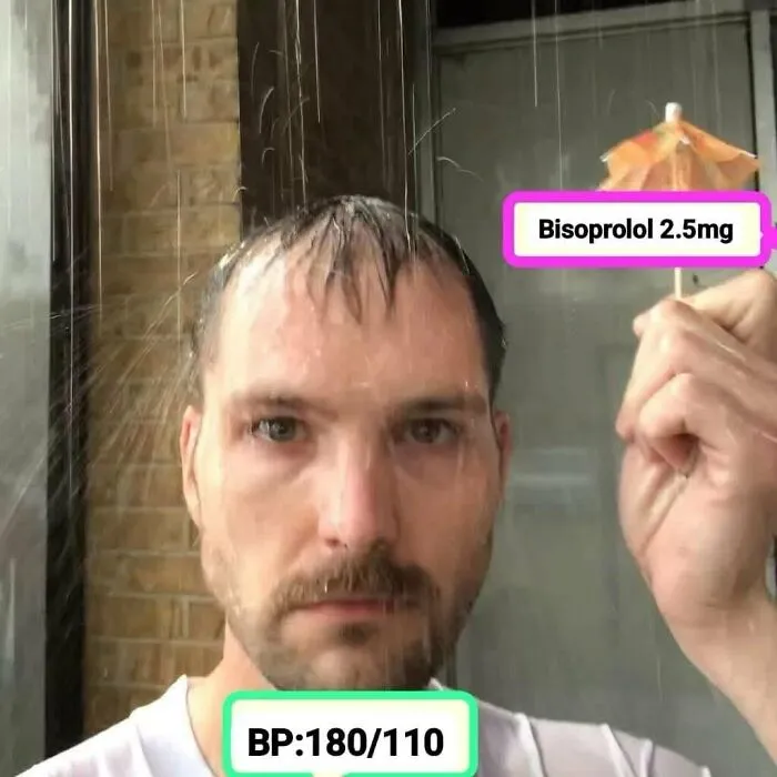 Man holding small umbrella labeled Bisoprolol 2.5mg with water spraying, illustrating humor about expensive healthcare and medication costs.