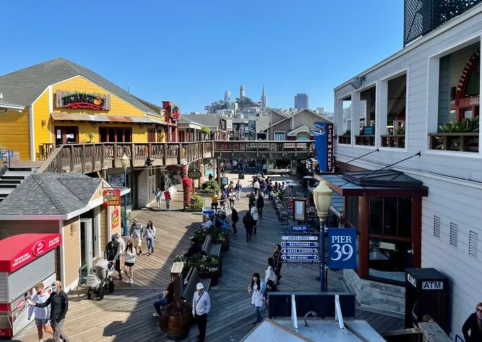 Crowded waterfront boardwalk with shops and tourists at a popular but disappointing tourist attractions location.