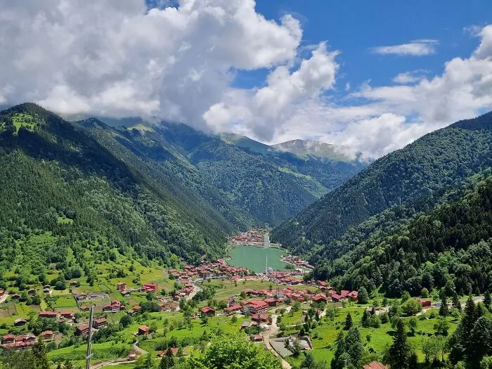 Scenic view of a village surrounded by mountains and a lake, showing disappointing tourist attractions locals don’t get.