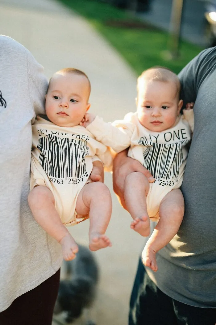 Two babies being held outdoors, illustrating unique medical facts about human development and health.