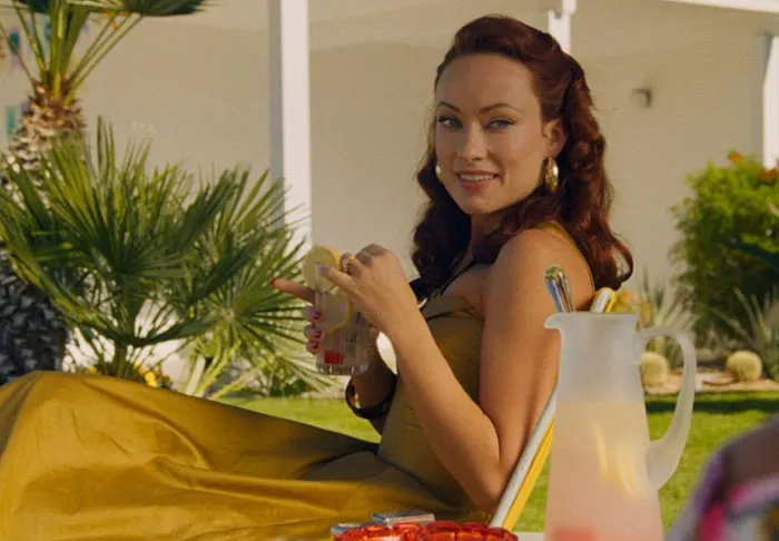 Woman in a yellow dress relaxing outdoors with a drink, representing celebrity infidelity scandals in a casual setting