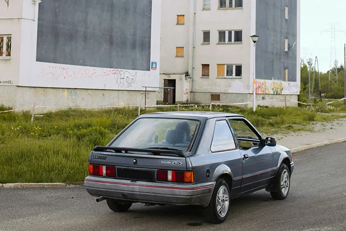 Old car parked near abandoned buildings, illustrating one of the most dangerous things people willingly or unwillingly did.
