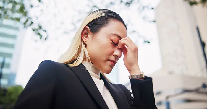 Young woman in a business suit with blonde hair, appearing thoughtful while reflecting on gifted kids and potential success.