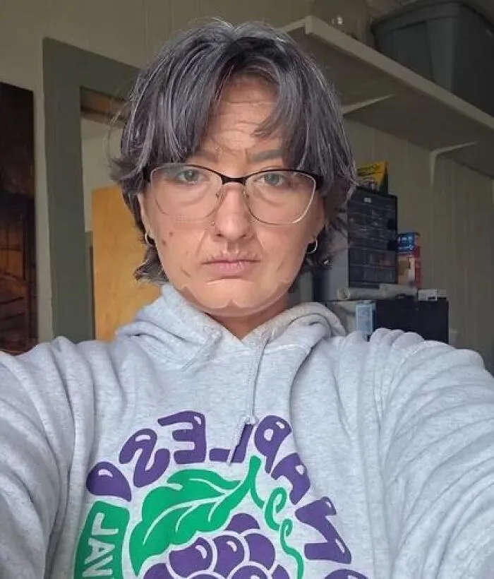 Person with gray hair and glasses wearing stage makeup that appears magical on stage but mildly cursed in real life.